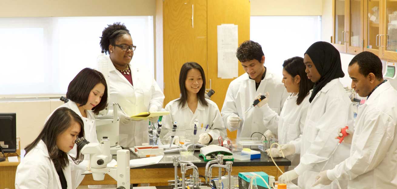 students in white coats in a lab