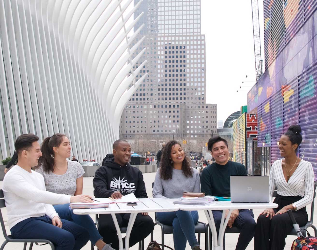 students at a table with city in background