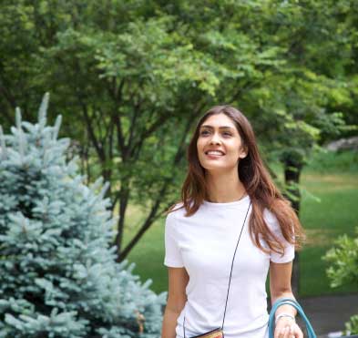 young woman walking along wooded path